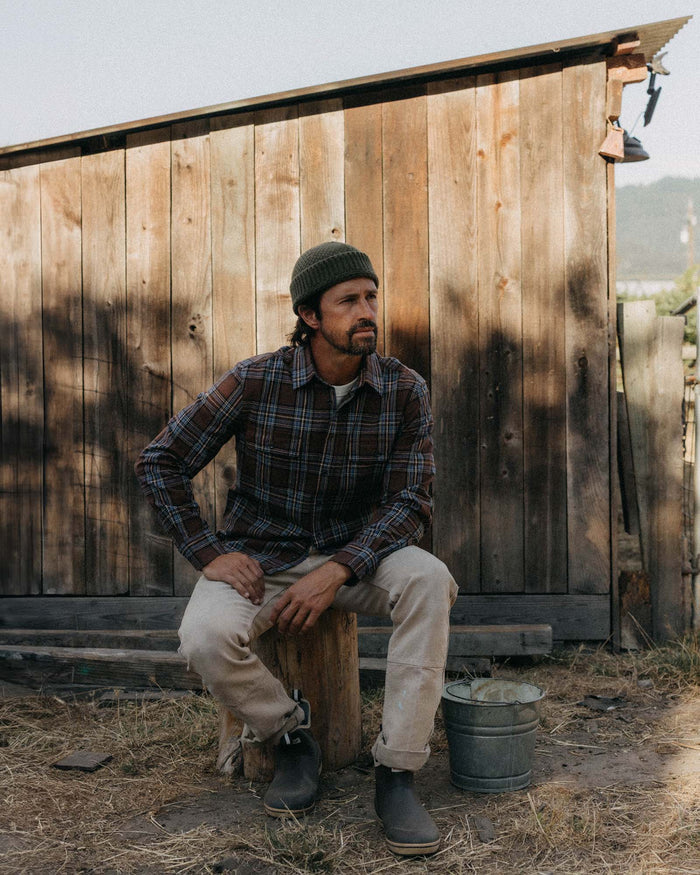 fit model sitting wearing The Craftsman Shirt in Brick Plaid