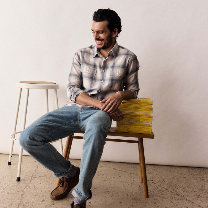 fit model sitting wearing The Craftsman Shirt in Sky Shadow Plaid