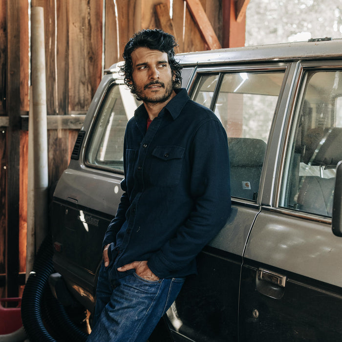 fit model leaning against a car in The Crater Shirt in Navy Twill