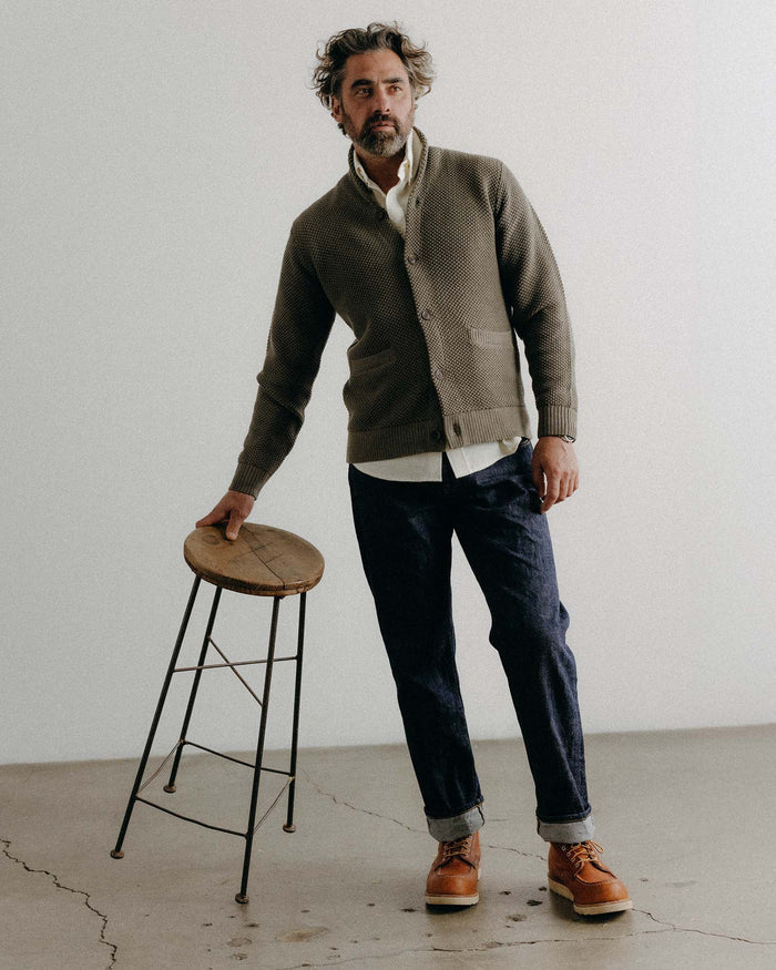 fit model with his hand in his pocket wearing The Crawford Sweater in Fatigue Olive