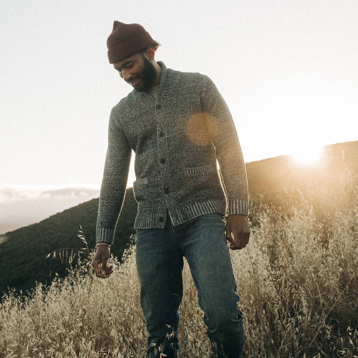 fit model wearing The Crawford Sweater, looking down, sun ray behind