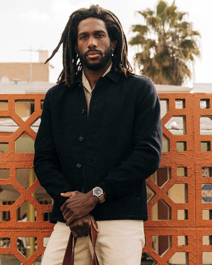 fit model leaning against the wall wearing The Crew Jacket in Raw Indigo Sashiko