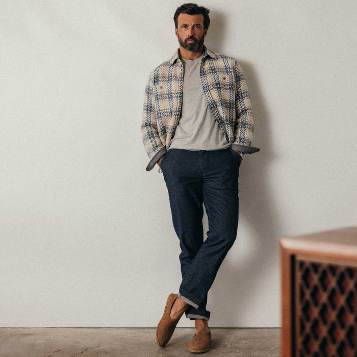 fit model leaning against the wall wearing The Cutter Overshirt in Sandbar Plaid