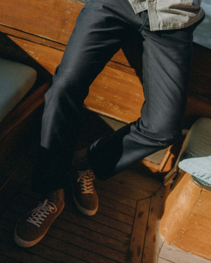 fit model sitting wearing The Deck Pant in Dark Navy Bedford Cord