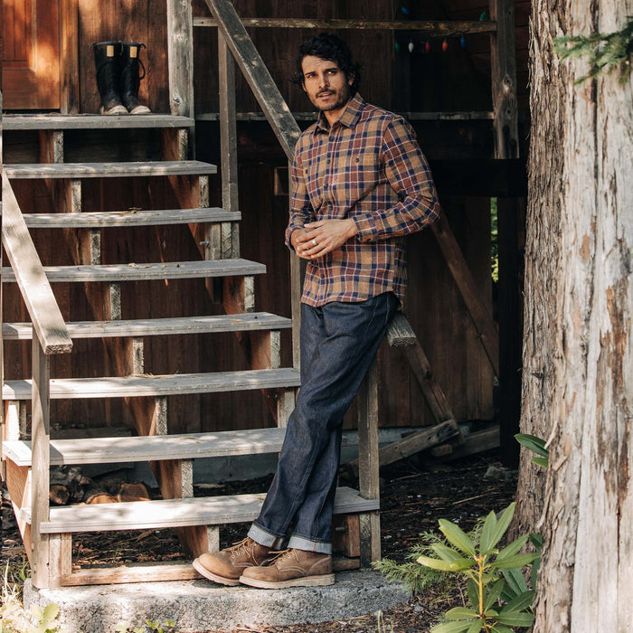 fit model leaning against the stairs wearing The Democratic Jean in Cone Mills Cordura Denim
