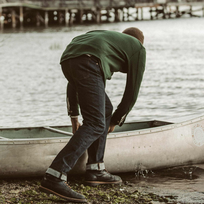 The fit model pushing the canoe out on the water