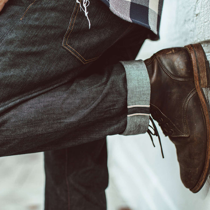 Our fit model with boots and cuffed denim jeans