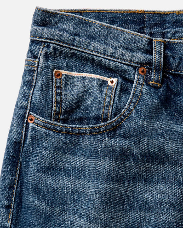 fit model sitting wearing The Democratic Jean in Mid Wash Organic Selvedge