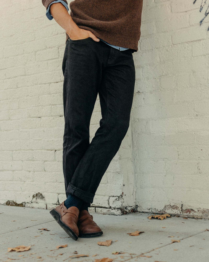 fit model walking wearing The Democratic Jean in Rigid Black Organic Selvedge