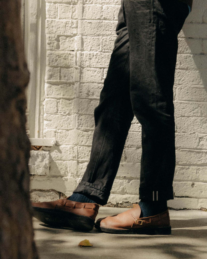 fit model standing wearing The Democratic Jean in Rigid Black Organic Selvedge