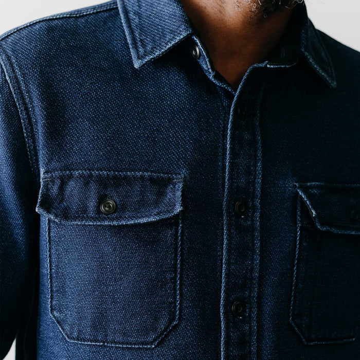 fit model adjusting the cuffs on The Division Shirt in Indigo Twill