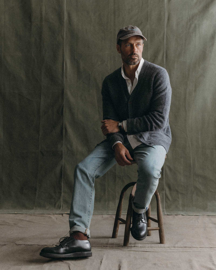 fit model sitting wearing The Eastmoor Cardigan in Heather Graphite Wool