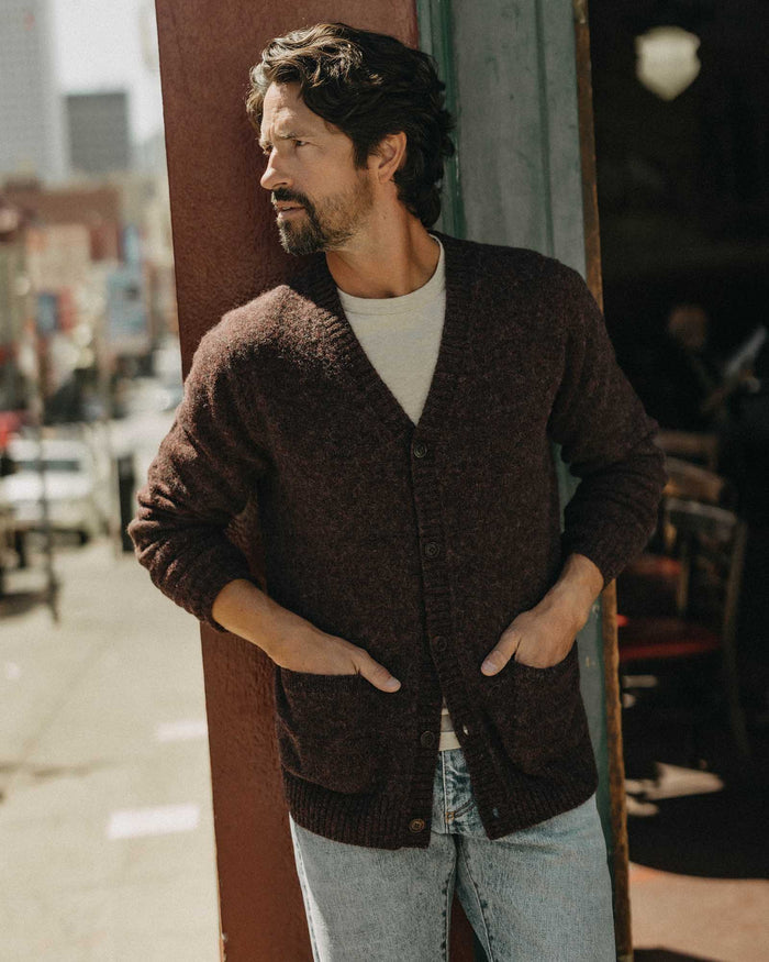fit model leaning against the wall wearing The Eastmoor Cardigan in Heather Port Wool