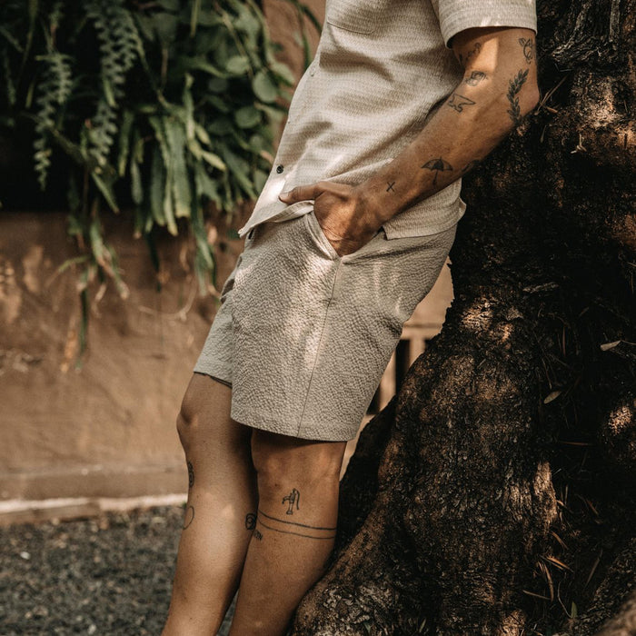 fit model leaning against a tree in The Easy Short in Heather Eucalyptus Seersucker