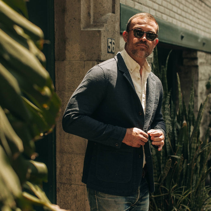 fit model wearing The Emerson Jacket in Navy Double Cloth, looking left of camera, plant on left