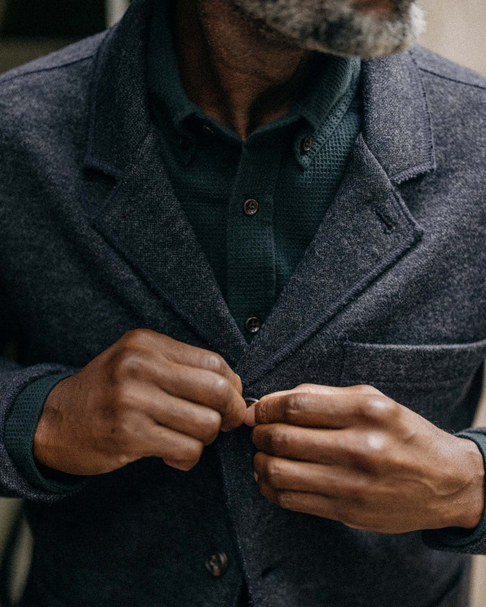 fit model buttoning The Ridgewood Cardigan in Navy Birdseye Wool