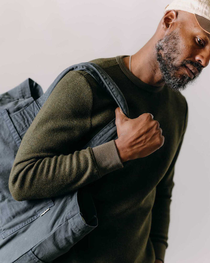 fit model with a bag over his shoulder wearing The Evans Crew in Forest Birdseye Wool
