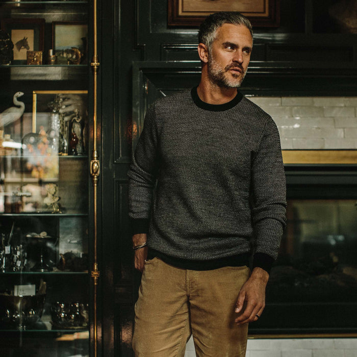 fit model wearing The Everett Sweater in Black Birdseye, looking right