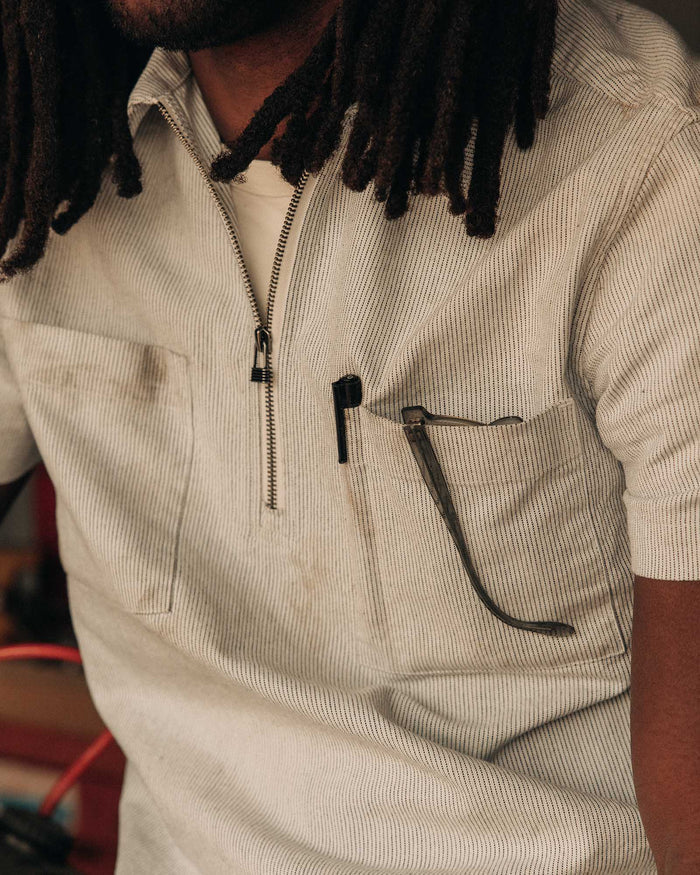 fit model sitting wearing The Exhaust Shirt in Natural Stripe