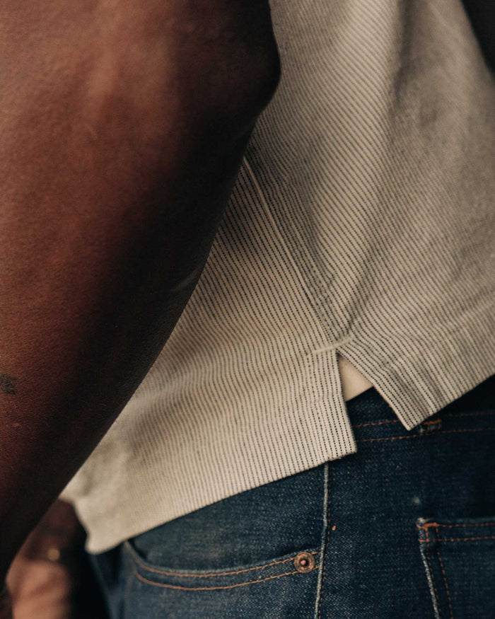 fit model showing off the bottom hem on The Exhaust Shirt in Natural Stripe
