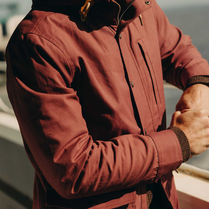 fit model leaning on a railing wearing The Explorer Jacket in Red Wine Dry Wax