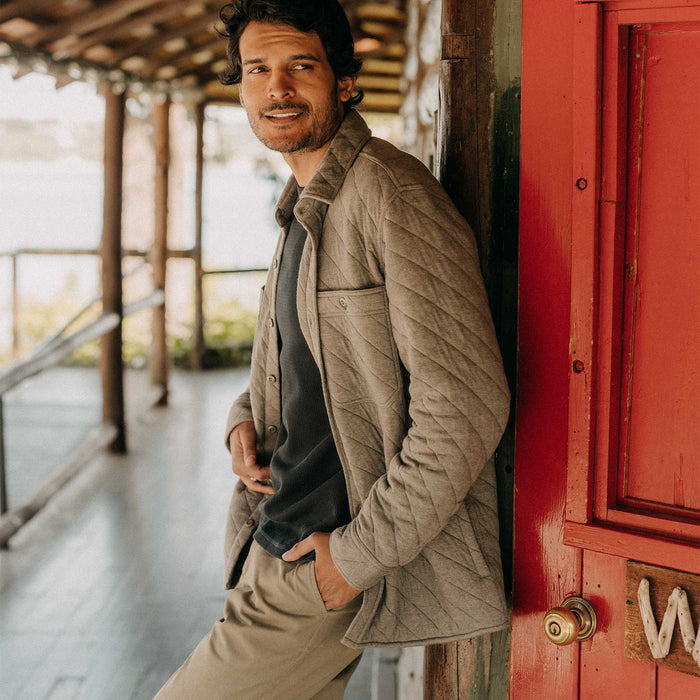 fit model leaning against the wall wearing The Fall Line Overshirt in Heather Ash Quilted Jersey