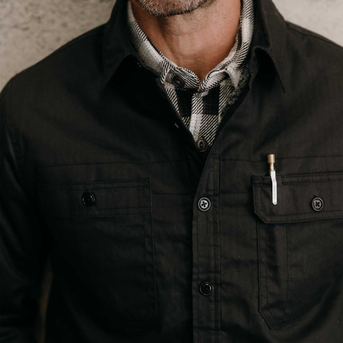 fit model showing off the pockets on The Fender Jacket in Coal Dry Wax