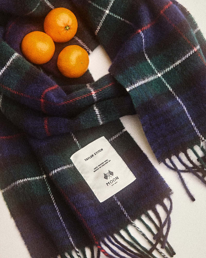 editorial image of The Fireside Scarf in Highland Navy Plaid with oranges