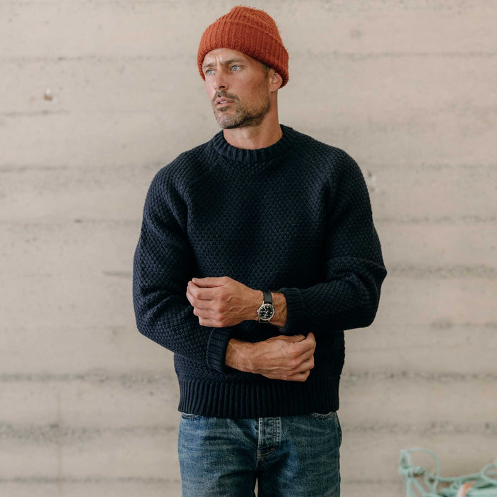 fit model adjusting the cuffs on The Fisherman Sweater in Dark Navy Merino