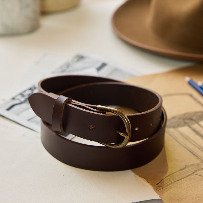 editorial image of The Foundation Belt in Dark Brown rolled up on sheets of paper