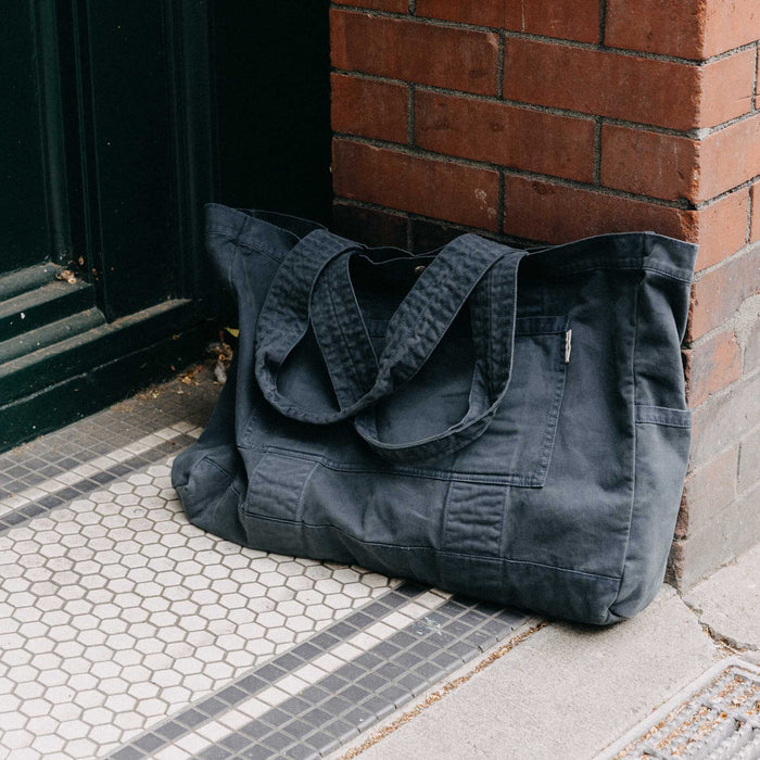 editorial image of The Foundation Tote in Organic Navy leaning against the wall