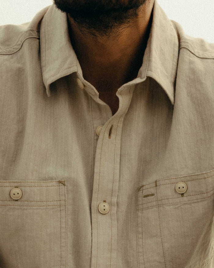 fit model showing off the buttons on The Foundry Shirt in Natural Chambray
