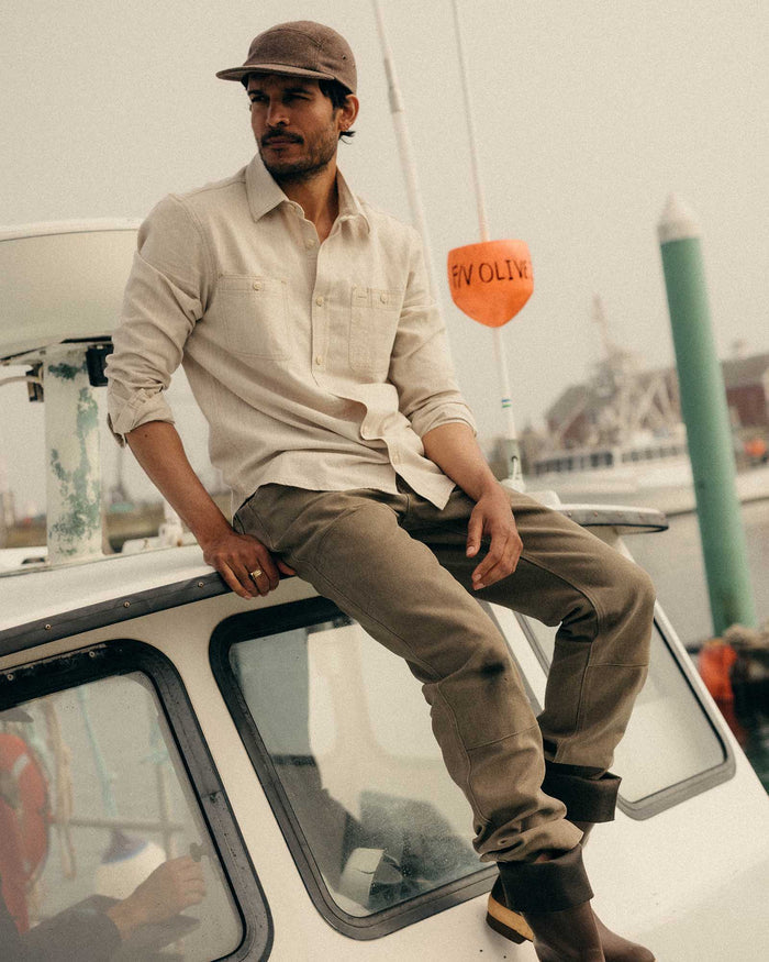 fit model sitting wearing The Foundry Shirt in Natural Chambray