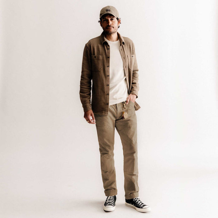 fit model with his hand in his pocket wearing The Good Acre Chore Pant in Tan Canvas