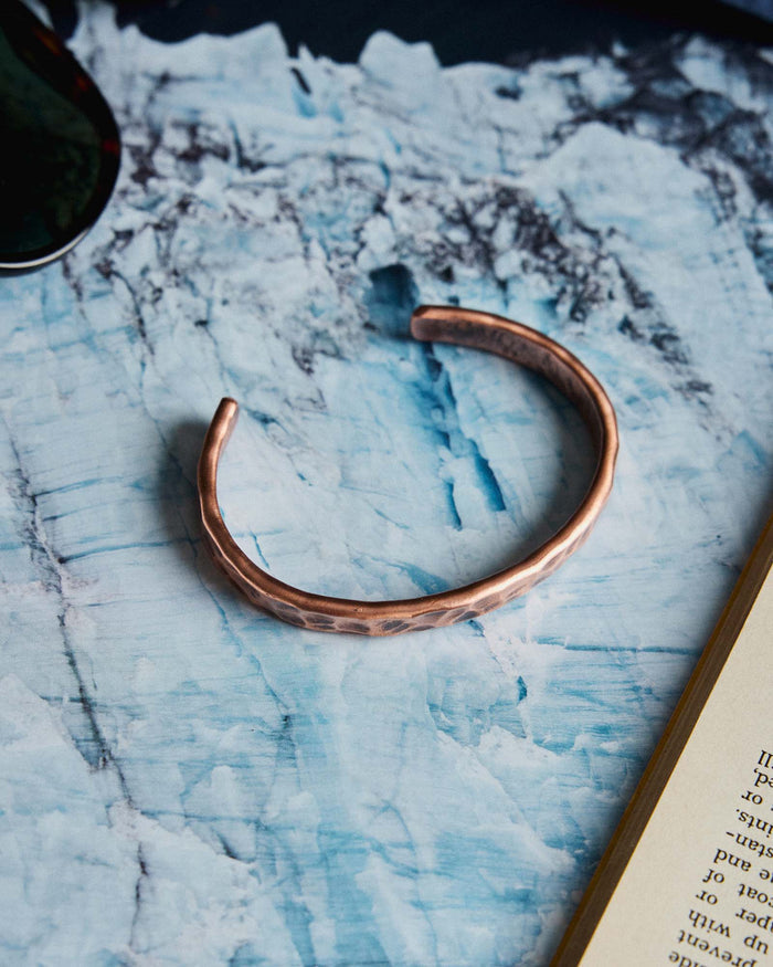 editorial image of The Hammered Cuff in Copper on a marble table