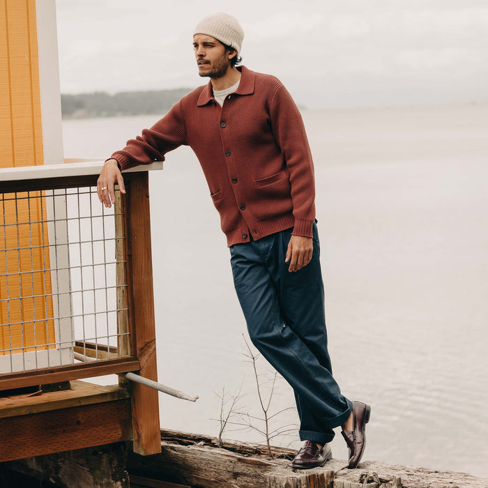 fit model leaning against the wall wearing The Harbor Sweater Jacket in Mahogany