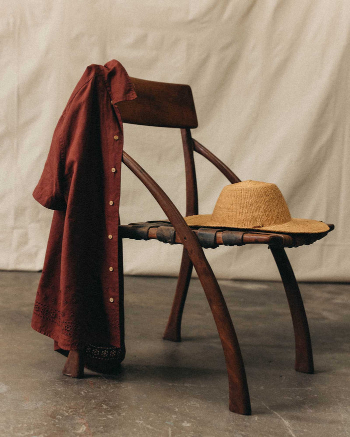 editorial image of The Hawthorne Shirt in Red Wine Border Eyelet hanging on a chair