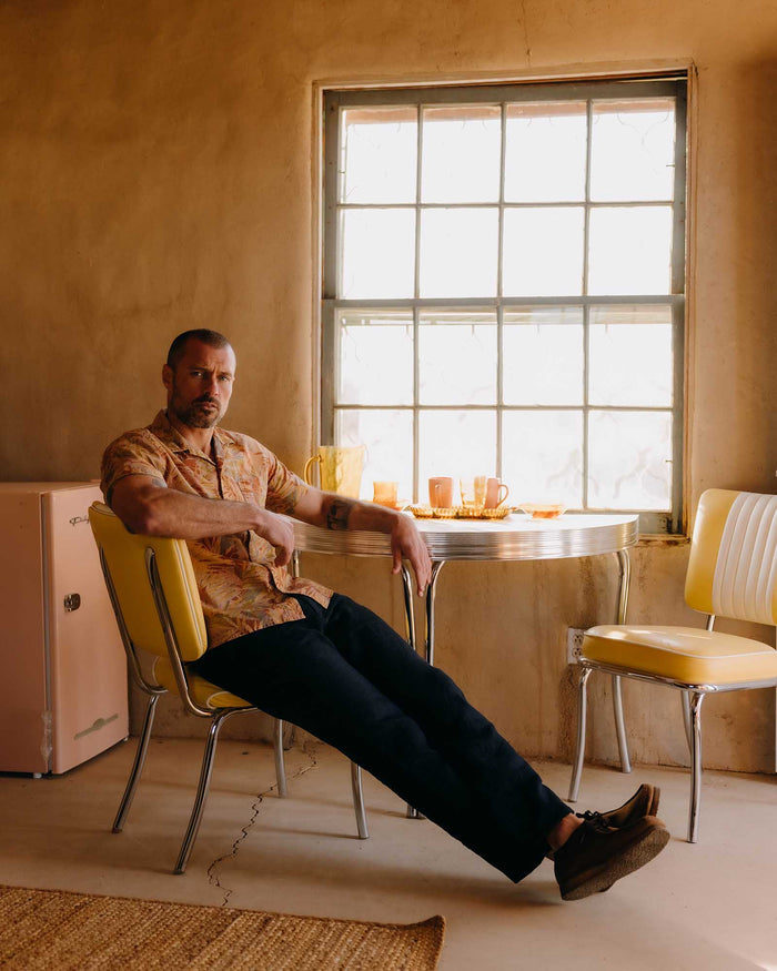 fit model sitting wearing The Hawthorne Shirt in Tea Desert Palm