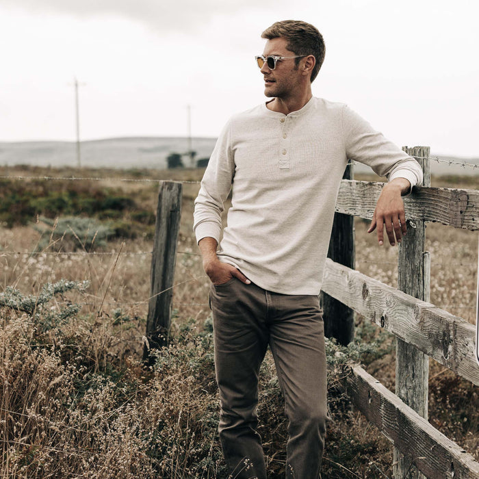 fit model posing against a fence in The Heavy Bag Henley in Oatmeal