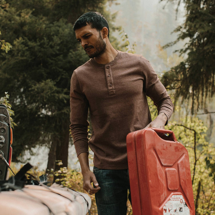 fit model wearing the heavy bag, holding gas can