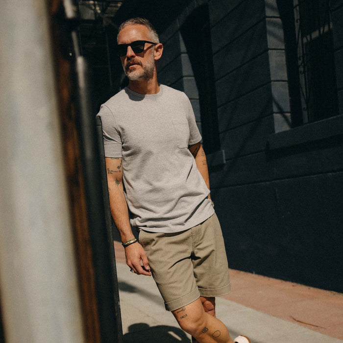 fit model leaning against the wall wearing The Heavy Bag Tee in Aluminum