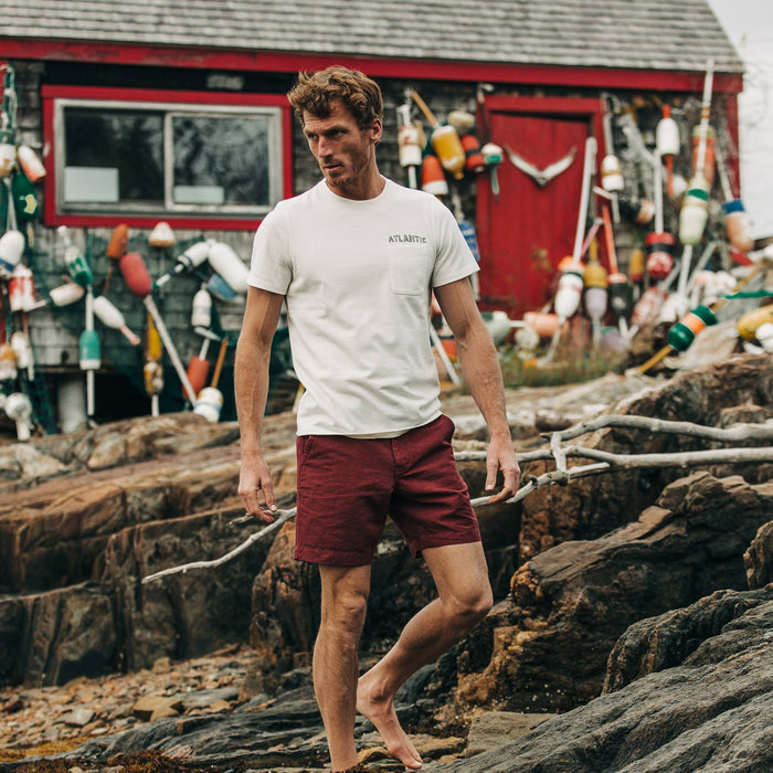 fit model wearing The Heavy Bag Tee in Atlantic, standing on rocks