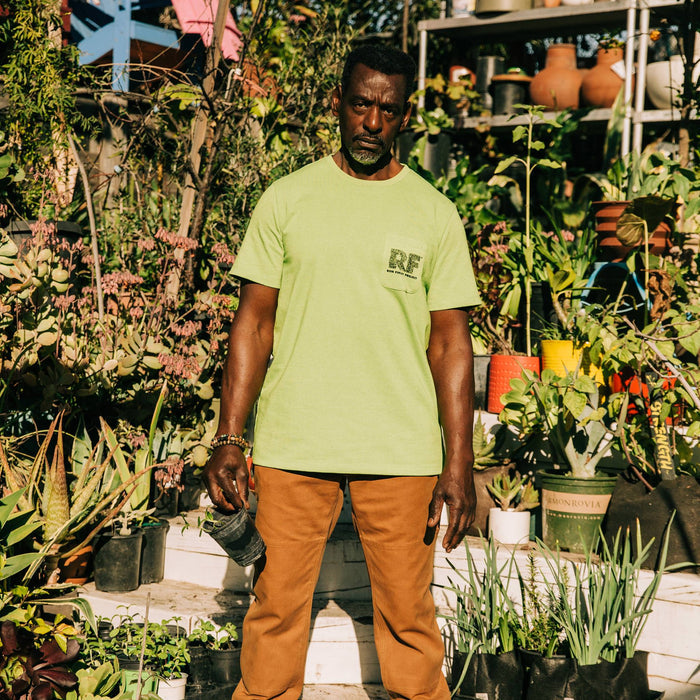 fit model wearing The Heavy Bag Tee in Chlorophyll in the garden