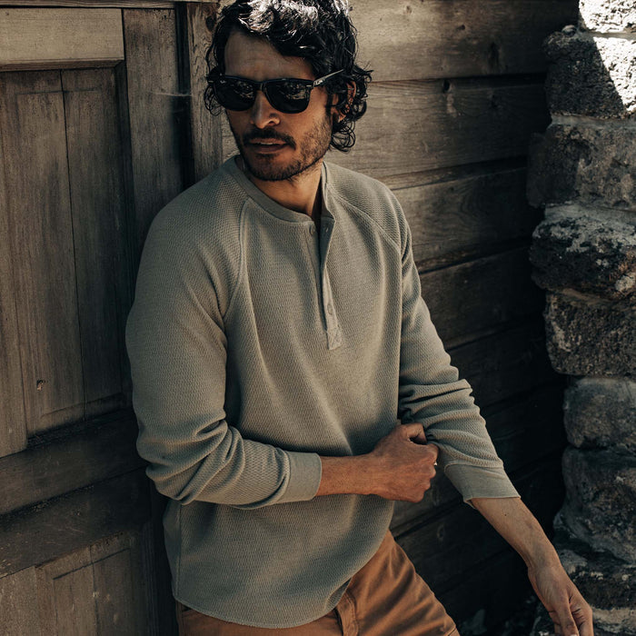 fit model adjusting sleeves on The Heavy Bag Waffle Henley in Army