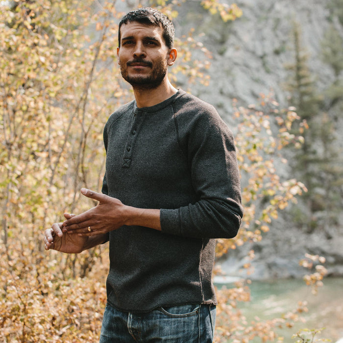fit model in a forest wearing The Heavy Bag Waffle Henley in Coal