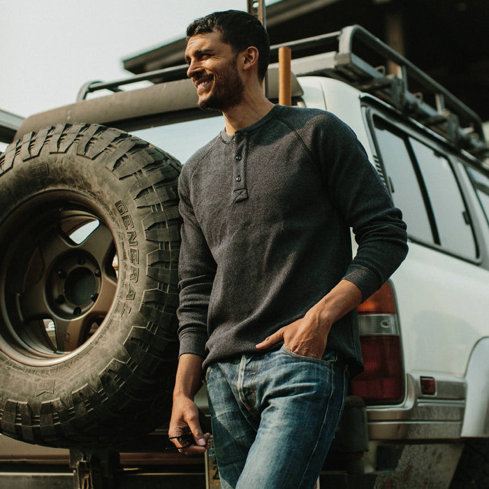 fit model leaning against a car in The Heavy Bag Waffle Henley in Navy