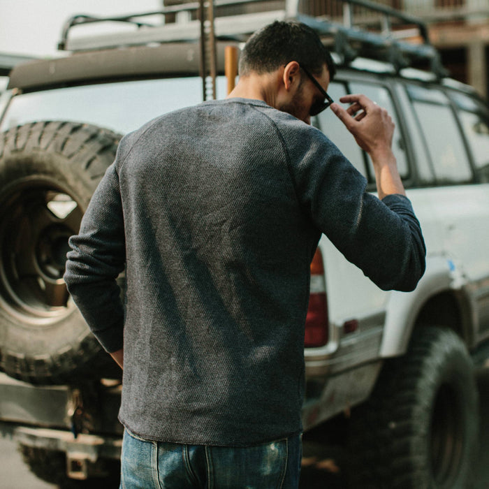 fit model putting on sunglasses in The Heavy Bag Waffle Henley in Navy