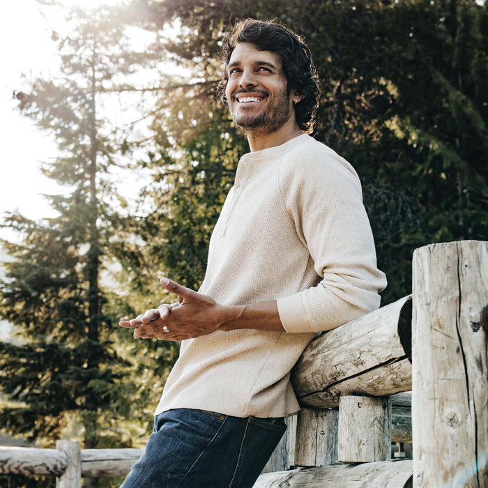 fit model leaning against a fence wearing The Heavy Bag Waffle Henley in Oatmeal