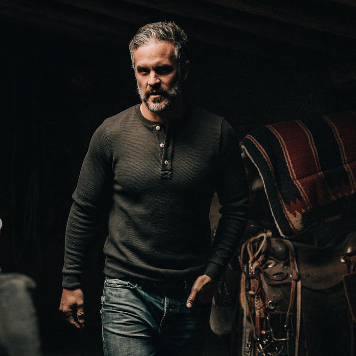 our fit model wearing The Heavy Bag Waffle Henley in Olive—walking inside
