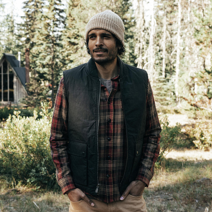 fit model with his hands in his pockets wearing The Ignition Vest in Coal Dry Wax